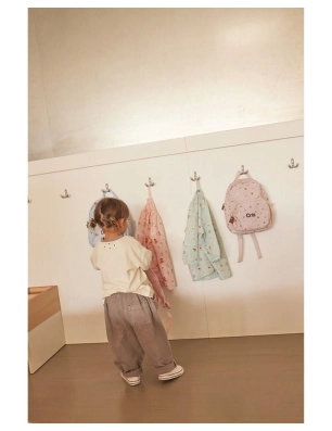 Niña colgando el Babi con botones Funny Letters de Tutete