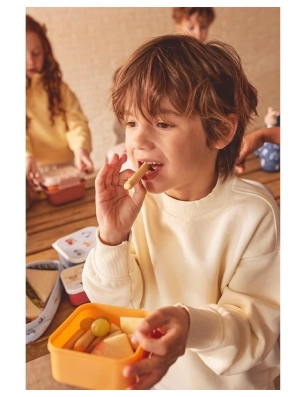 Niño comiendo con el Pack 3 Cajas Almuerzo Funny Letters de Tutete