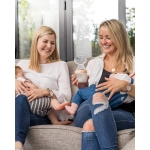 Dos mujeres dando el pecho a dos bebés con un Recolector Leche Generation 3 de Haakaa en la mano.