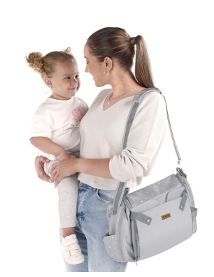 Madre con niña en brazos llevando la Trona de Viaje Avant de Jané U05 Dim Grey como bolso al hombro