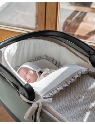 Saco cuco invierno Little Bloom de Pasito a Pasito colocado en un capazo con un bebé